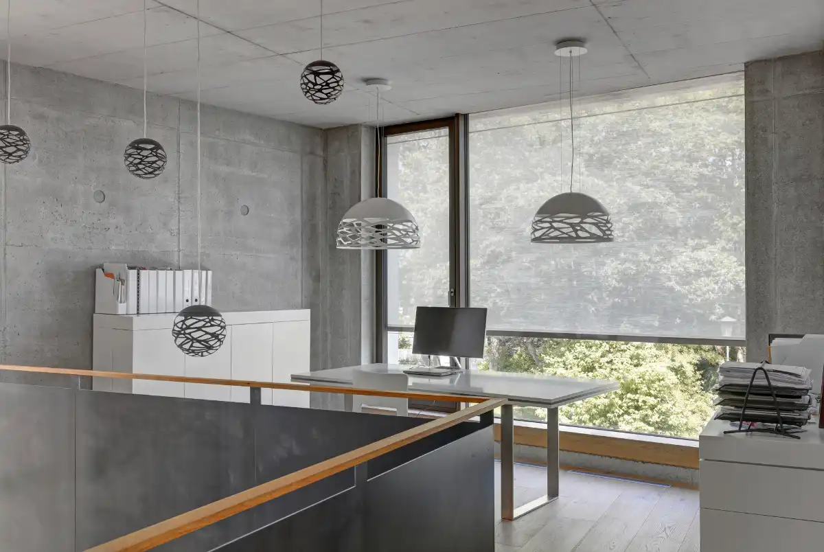 Modernes Büro mit Betonwänden und stilvoller Beleuchtung