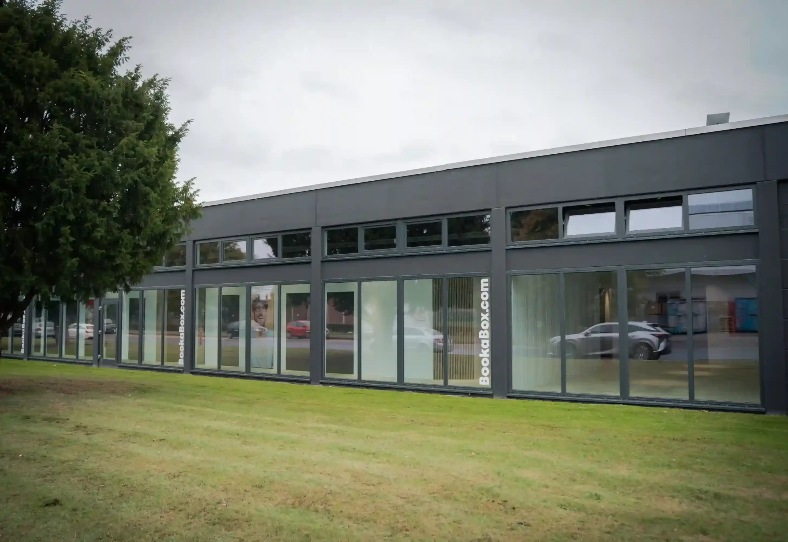 Smart Home für den Wohnbereich Lange Fensterfassade an einem modernen grauen Gebäude.